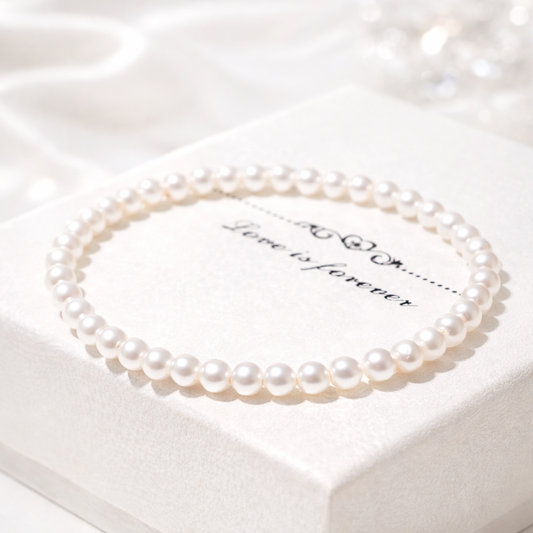 Pearl necklace on a white box with 'Love is forever' text